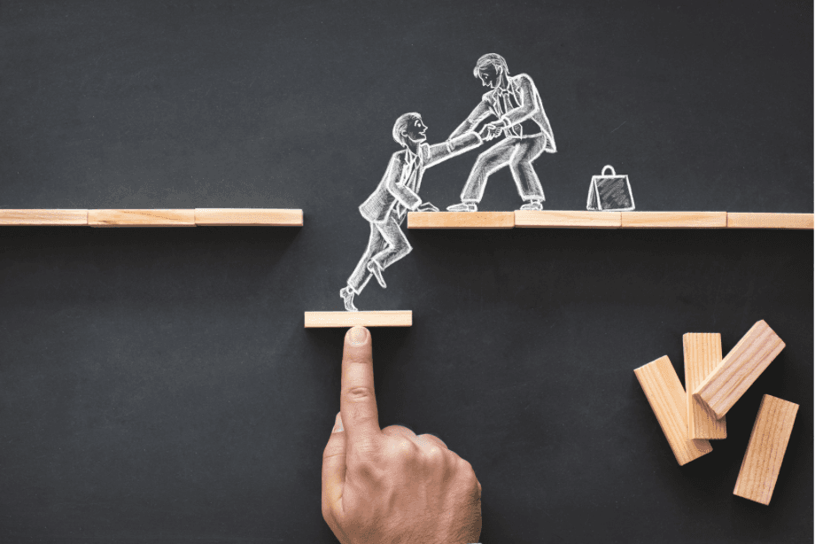 a man helping another man climb up a step